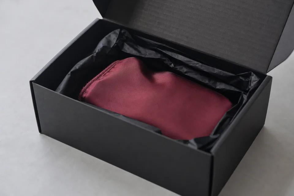 A plain black box with tissue and an unmarked pouch, ready to ship